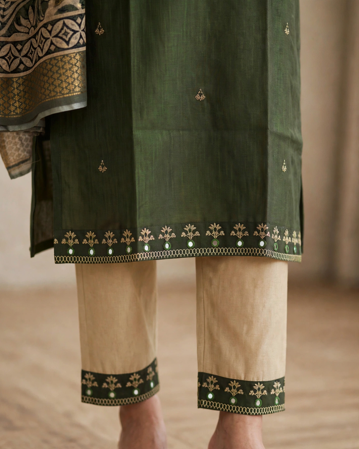 Olive green kurta hem border and beige pant detail close up